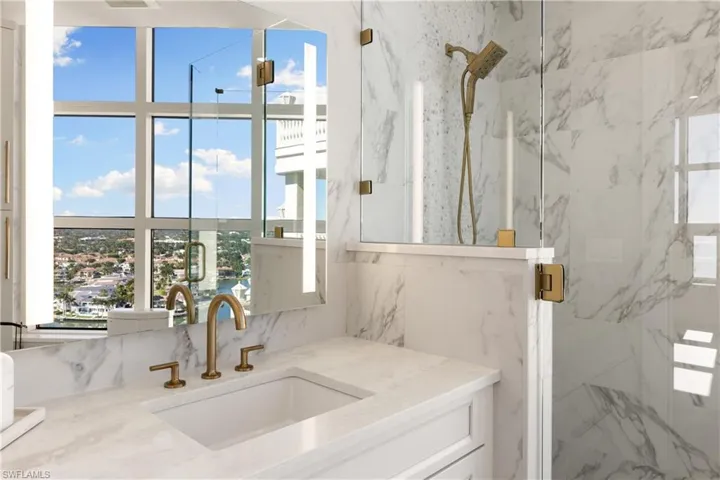Bathroom view of vanity and a marble finish shower