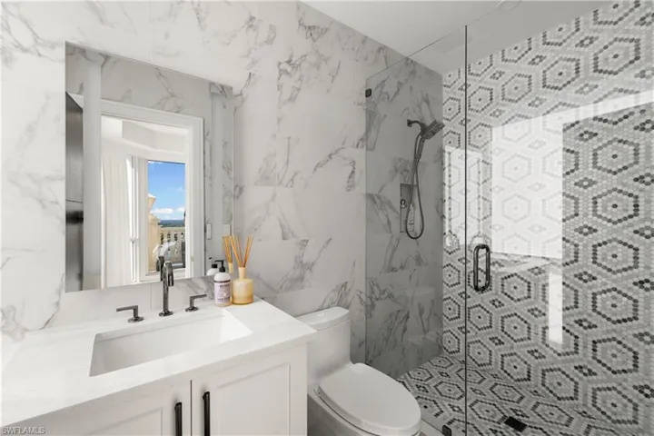 Full bathroom with a shower stall, vanity, and tile walls