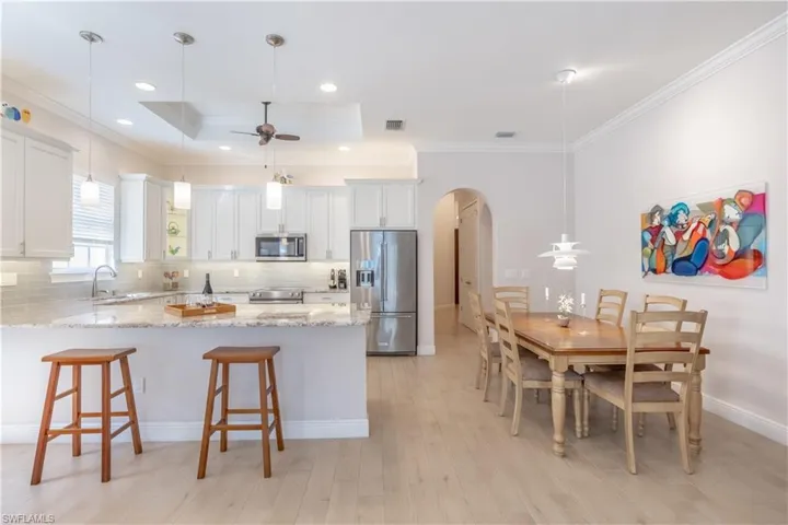 Kitchen with pendant lighting, stainless steel appliances, sink, and white cabinetry