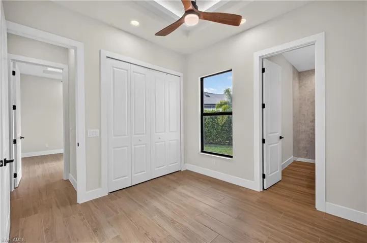 Room with wood-look tile flooring, white walls, and a contemporary ceiling fan
