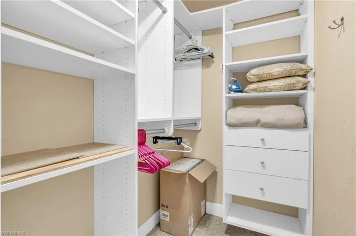 Spacious closet featuring carpet flooring, virtually enhanced image