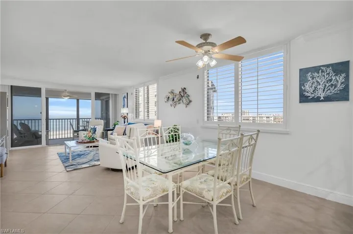 Tiled dining room with ceiling fan, plenty of natural light, and ornamental molding, virtually enhanced image