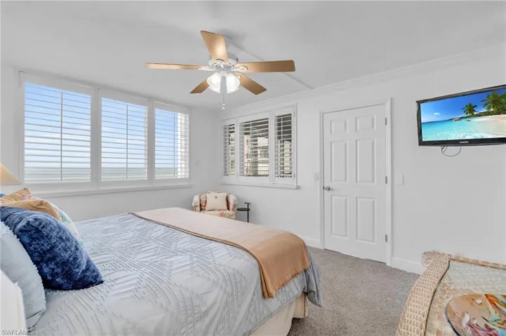Bedroom with carpet flooring, ceiling fan, and crown molding, virtually enhanced image
