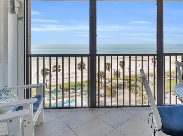 Balcony featuring a view of the beach and a water view virtually enhanced image