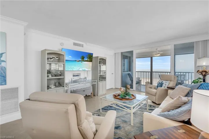 Tiled living room with ceiling fan and ornamental molding, virtually enhanced image