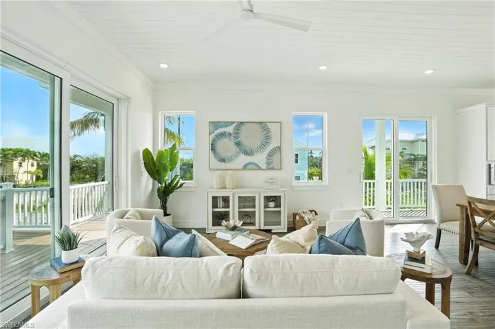 Living room featuring wood finished floors, crown molding, a ceiling fan, and recessed lighting