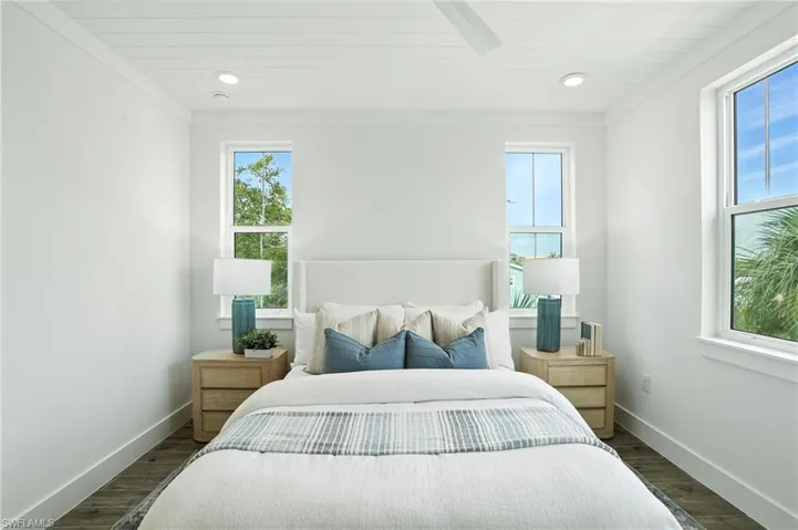 Bedroom with dark wood-type flooring, recessed lighting, crown molding, and wood ceiling