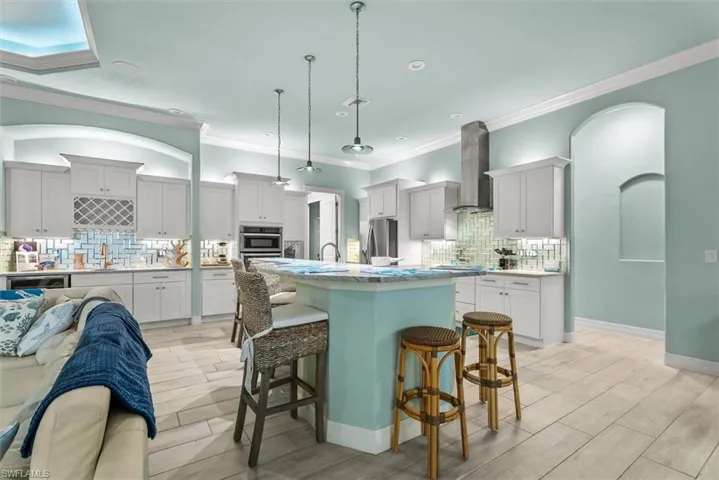 Spacious kitchen with a central island featuring a light blue base and a light-colored countertop