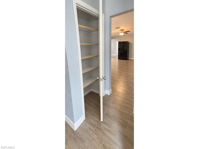 Built-in shelving, wood-finish flooring, recessed lighting, and ceiling fan
