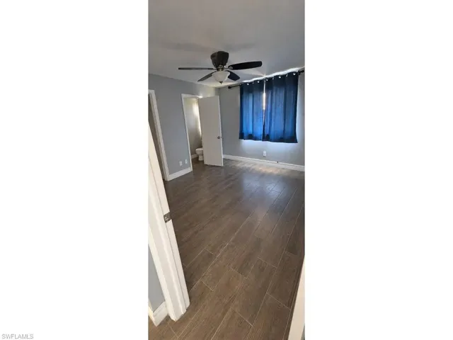 Wood-finish flooring, ceiling fan, and light gray wall paint