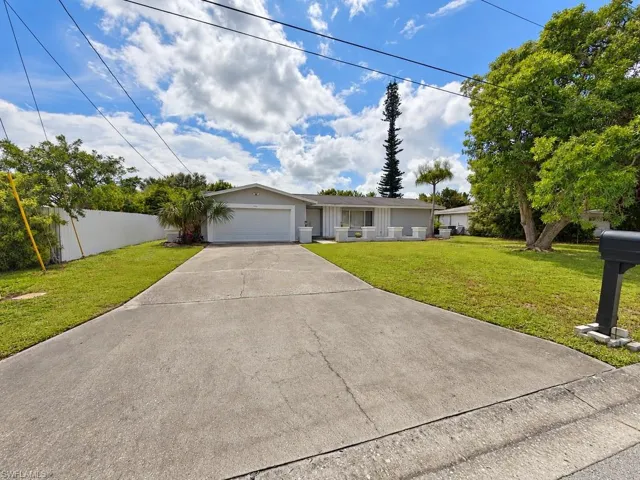 Single-story exterior with an attached garage, concrete driveway, and front lawn