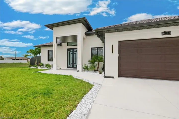 View of front facade featuring a garage and a front yard