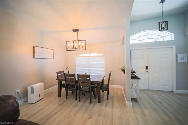 Dining area with a chandelier, light wood-style flooring, and plenty of natural light