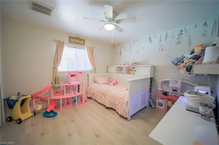 Bedroom with light wood finished floors and a ceiling fan