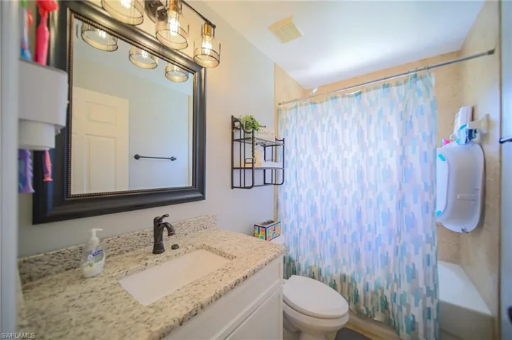 Bathroom featuring vanity and shower / bath combo with shower curtain