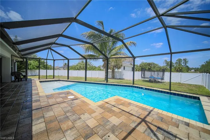 View of pool featuring a patio, a trampoline, a fenced backyard, and a lanai