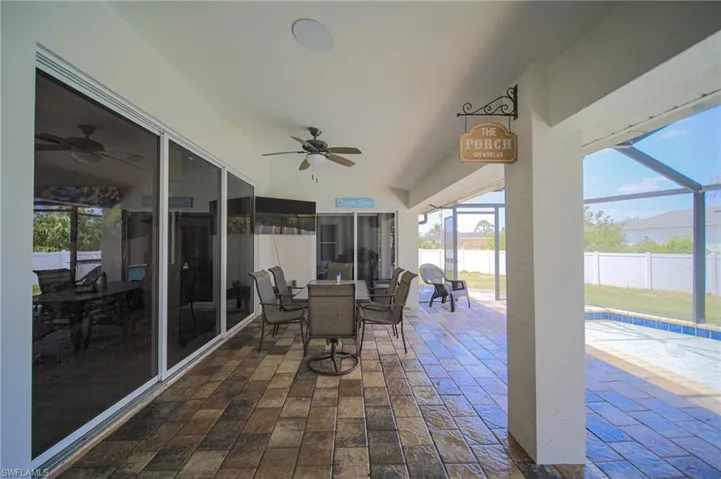 View of patio featuring ceiling fan, a lanai, and outdoor dining space