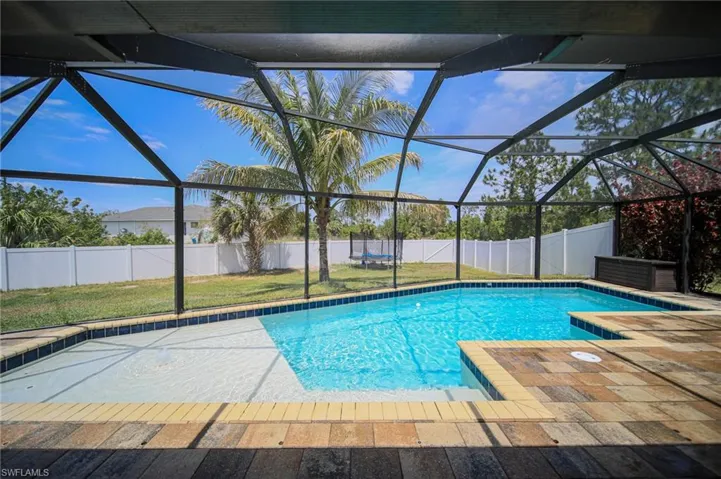 View of swimming pool with a lanai, a fenced backyard, and a patio