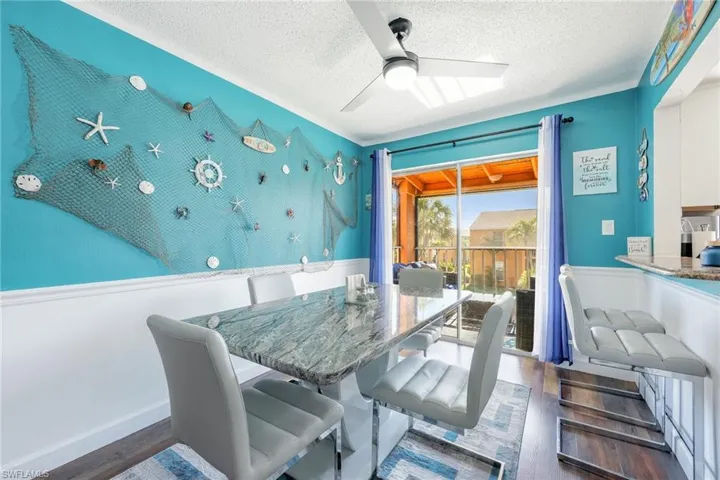 Dining space featuring a textured ceiling, ceiling fan, and dark hardwood / wood-style flooring