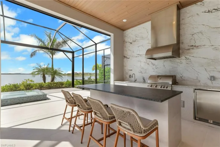 View of patio / terrace with area for grilling, a sunroom, glass enclosure, and a water view