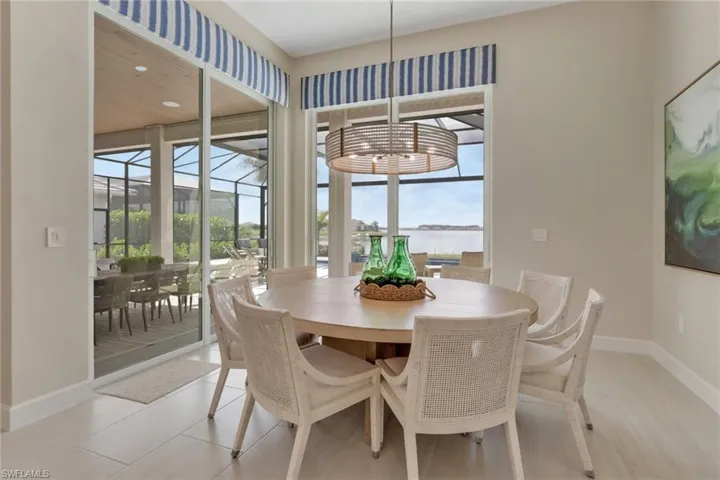 Dining area featuring a sunroom, a water view, recessed lighting, and light tile patterned floors