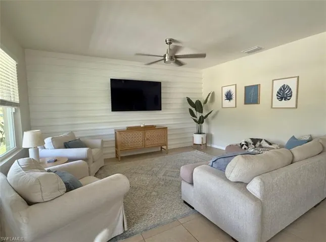 Tiled living area featuring visible vents and a ceiling fan