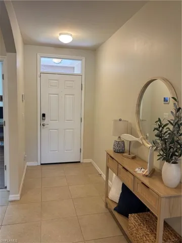 Entrance foyer with light tile patterned flooring and baseboards