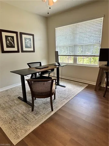 Office area featuring wood finished floors, ceiling fan, and baseboards