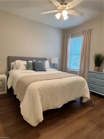 Bedroom with dark wood-style floors and ceiling fan