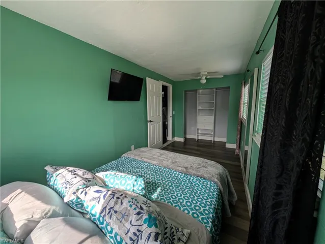 Bedroom with wood finished floors and a closet