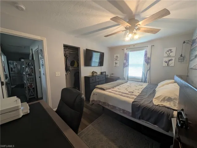Bedroom with wood finished floors, a closet, and ceiling fan