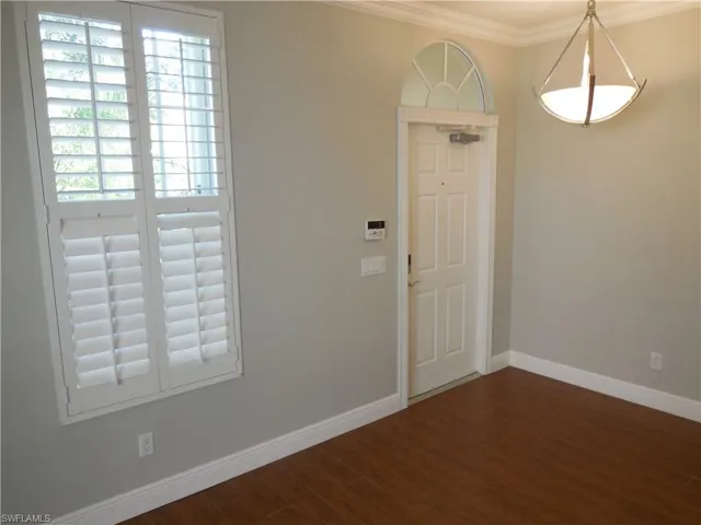 Foyer with crown molding and dark hardwood / wood-style floors