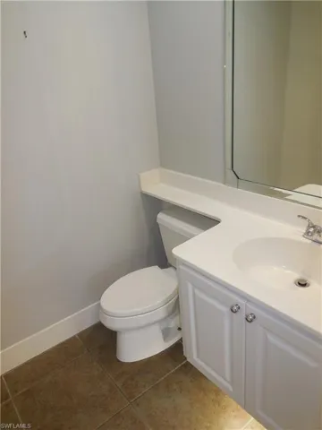 Bathroom with tile patterned flooring, vanity, and toilet