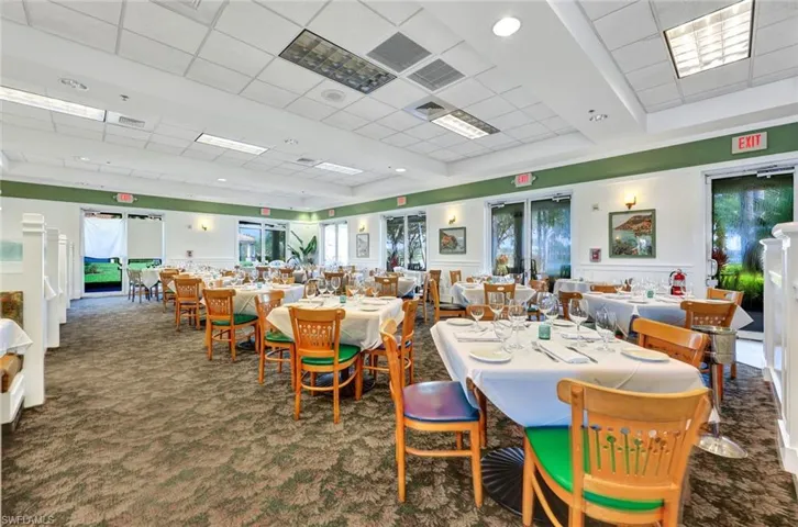Dining space with plenty of natural light, a drop ceiling, and dark carpet