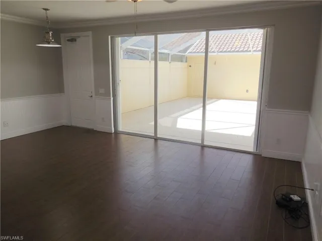 Spare room with dark wood-type flooring, ornamental molding, and ceiling fan