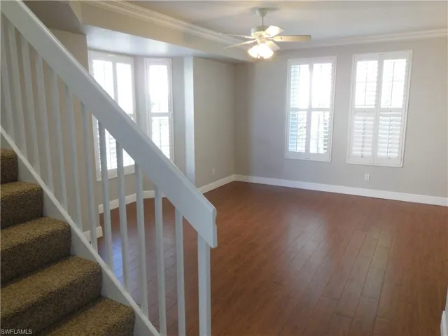 Stairs featuring crown molding, hardwood / wood-style floors, and a wealth of natural light