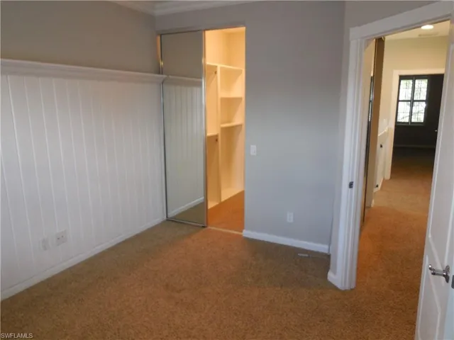 Unfurnished bedroom with a spacious closet, a closet, and carpet