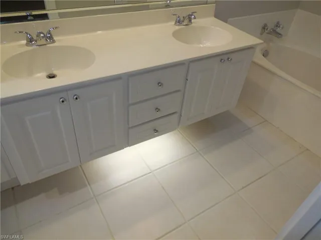 Bathroom featuring vanity, a tub to relax in, and tile patterned flooring
