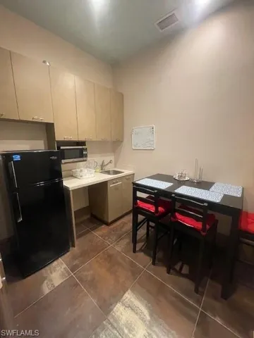 Kitchen featuring sink, fridge, and tile patterned floors