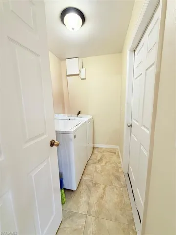 Laundry area featuring independent washer and dryer and baseboards