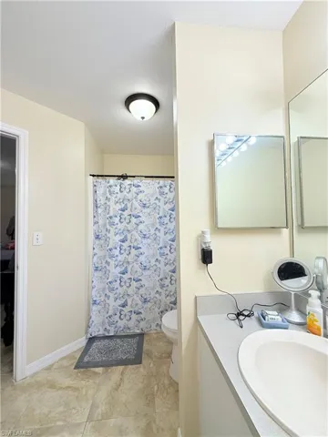 Bathroom with vanity and curtained shower