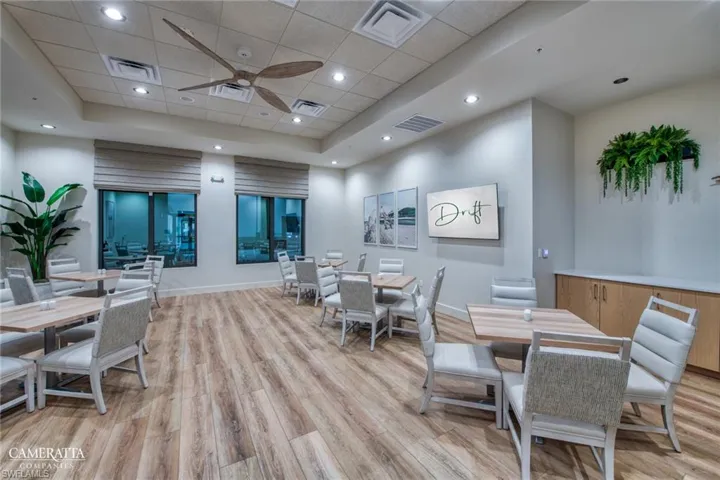 Dining space featuring light wood-style floors, baseboards, a ceiling fan, a paneled ceiling, and a tray ceiling