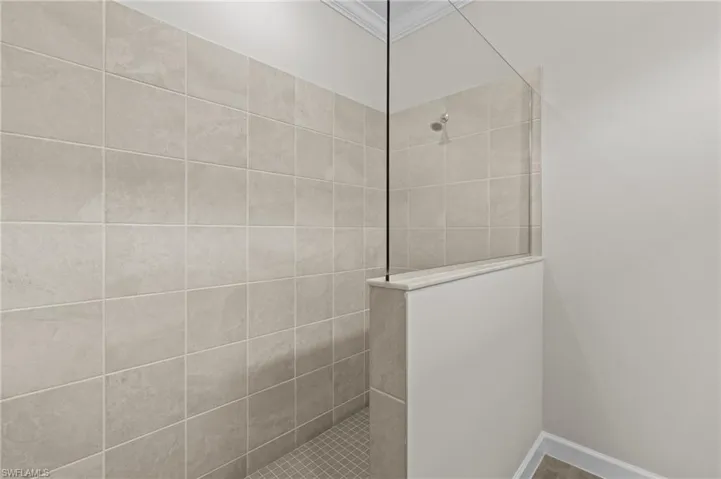 Full bathroom with walk in shower and ornamental molding