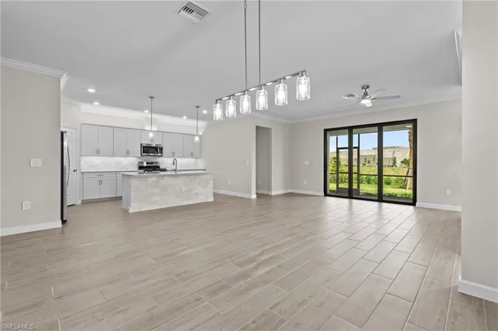Unfurnished living room featuring ornamental molding, baseboards, a ceiling fan, light wood-style flooring, and recessed lighting