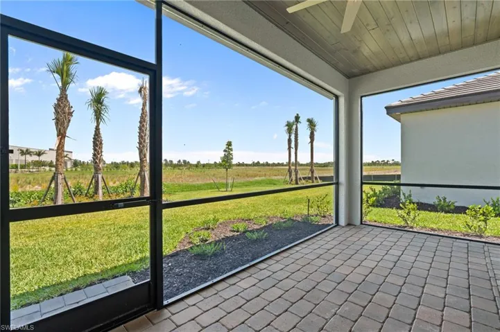 Unfurnished sunroom with ceiling fan and a view of countryside