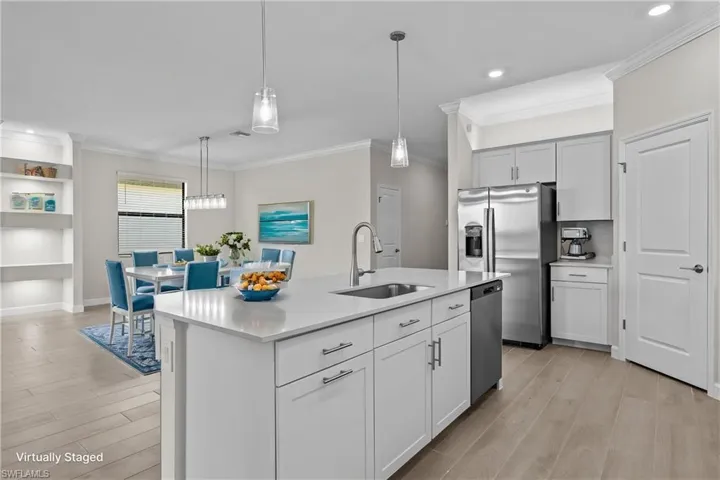 Kitchen featuring a sink, stainless steel appliances, light countertops, light wood-style floors, and pendant lighting