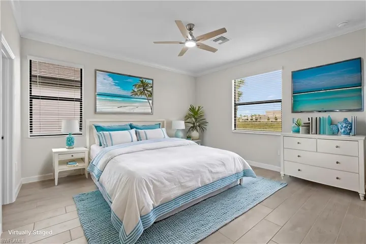 Bedroom with ornamental molding, baseboards, light wood-style flooring, and a ceiling fan