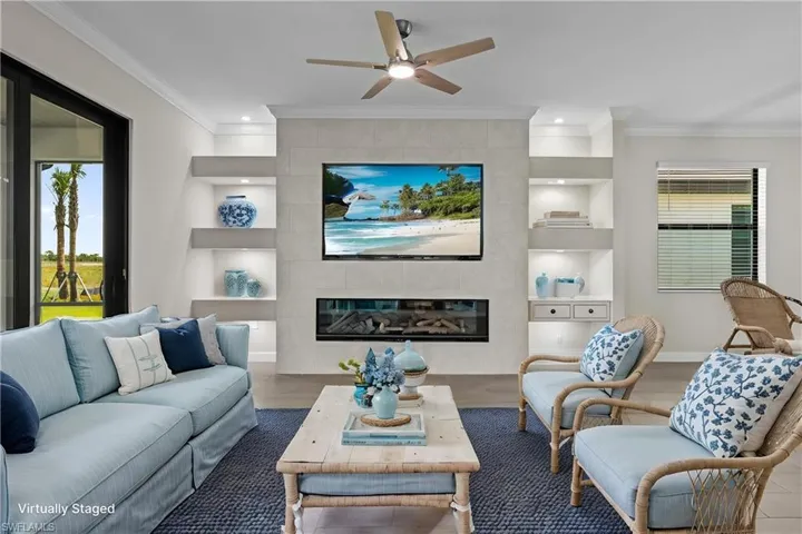 Living area with built in features, a fireplace, plenty of natural light, crown molding, and recessed lighting