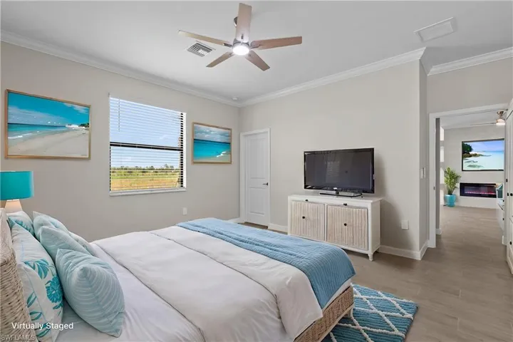Bedroom with crown molding, light wood-style flooring, baseboards, and ceiling fan