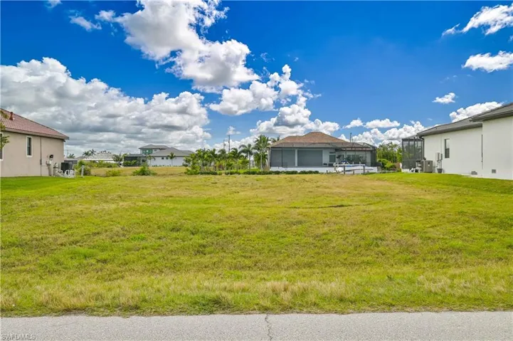 View of green lawn with a residential view